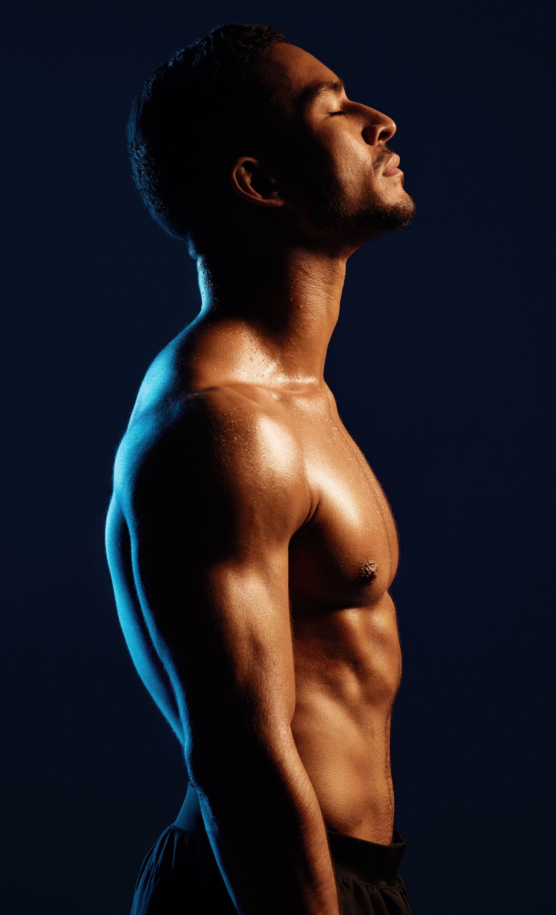 Studio shot of a fit young man posing against a black background